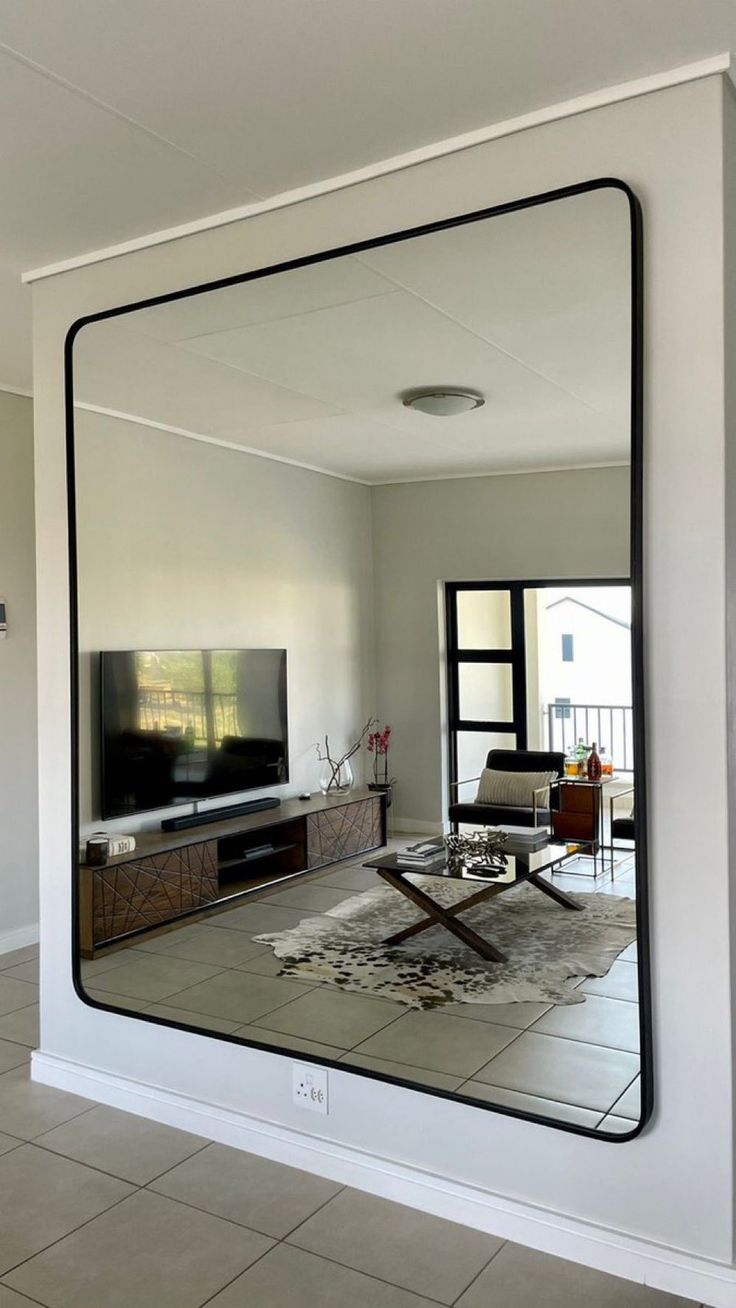 a living room with a large mirror on the wall