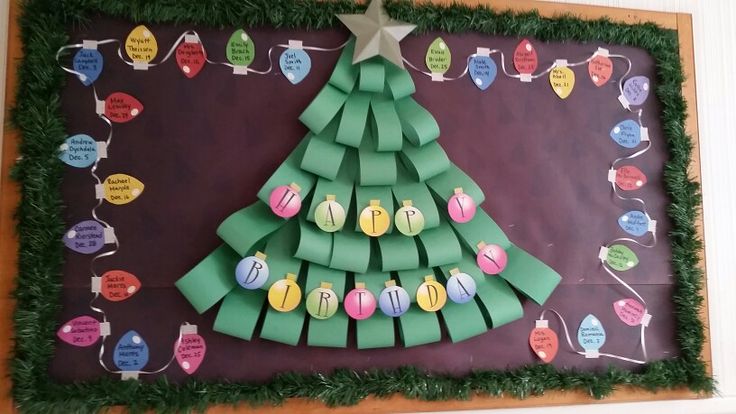 a christmas tree made out of pieces of paper on a bulletin board with green grass