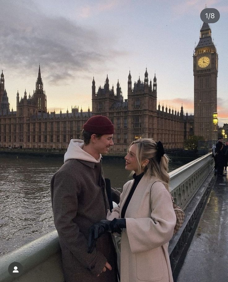 a man and woman standing next to each other in front of the big ben clock tower