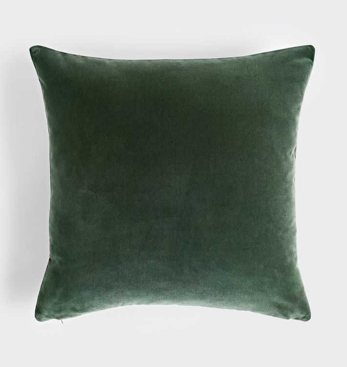 a green velvet pillow on a white background