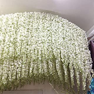 white flowers hanging from the side of a building