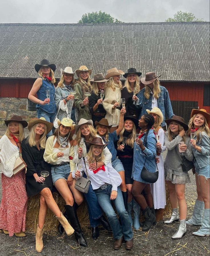 a group of people standing next to each other on top of a hay bale