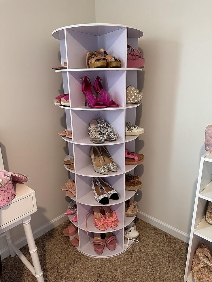 there is a white shelf with many pairs of shoes on it and a chair in the corner