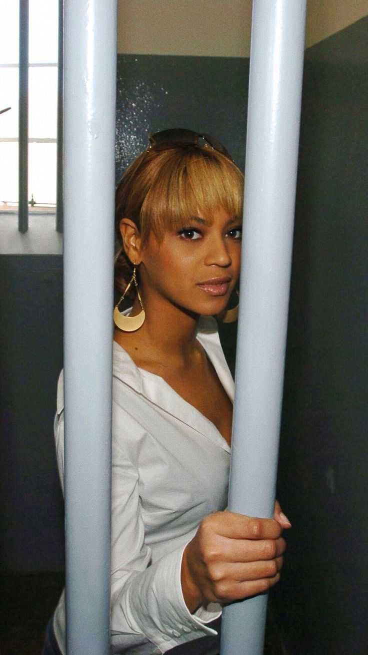 a woman behind bars in a jail cell