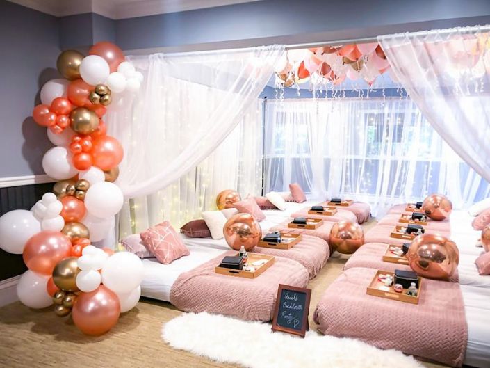 a bed room filled with lots of pink and gold balloons