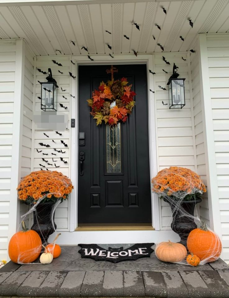 the front door is decorated for halloween with pumpkins and decorations