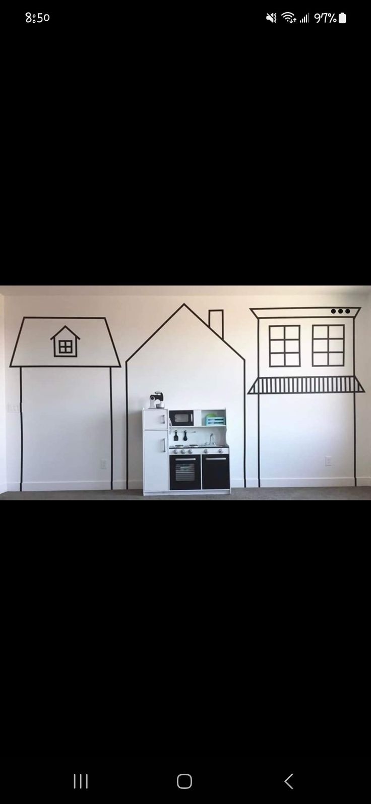 an appliance is displayed in front of a wall with houses painted on it