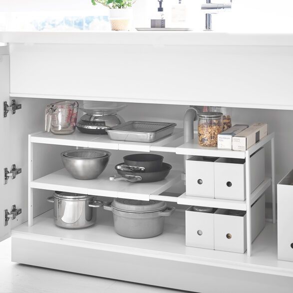 an open cabinet with pots and pans on it