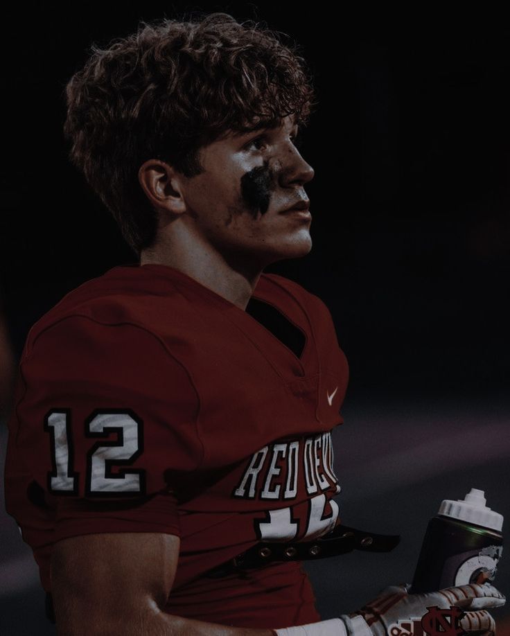 a football player with his face painted in the colors of texas and holding a drink