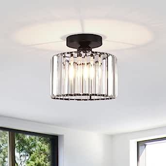 a light that is hanging from the ceiling in a room with white walls and windows