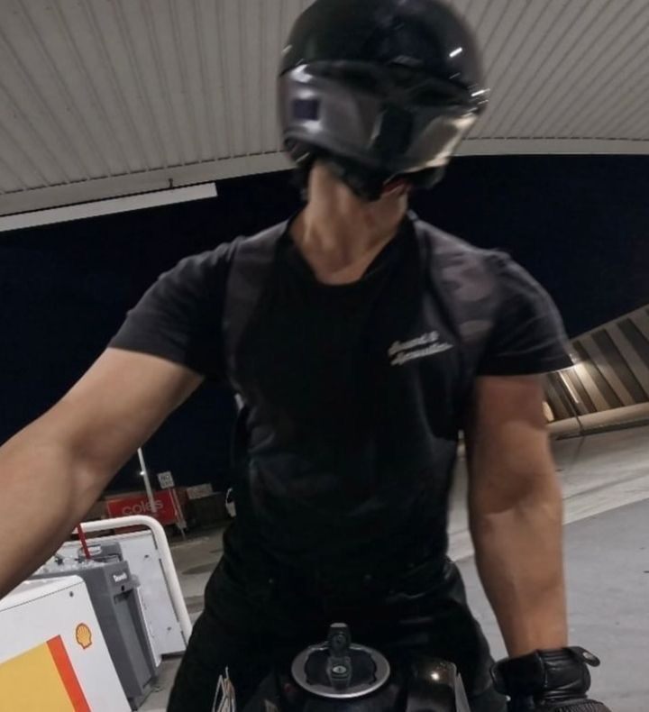 a man in black shirt and helmet riding on top of a skateboard at an airport