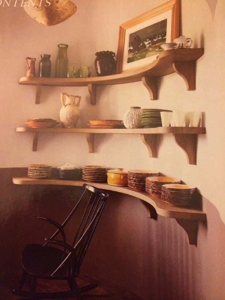 a wooden chair sitting in front of a shelf filled with plates and bowls on top of it