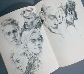 an open book with drawings of people's faces on it and the pages are drawn in pencil