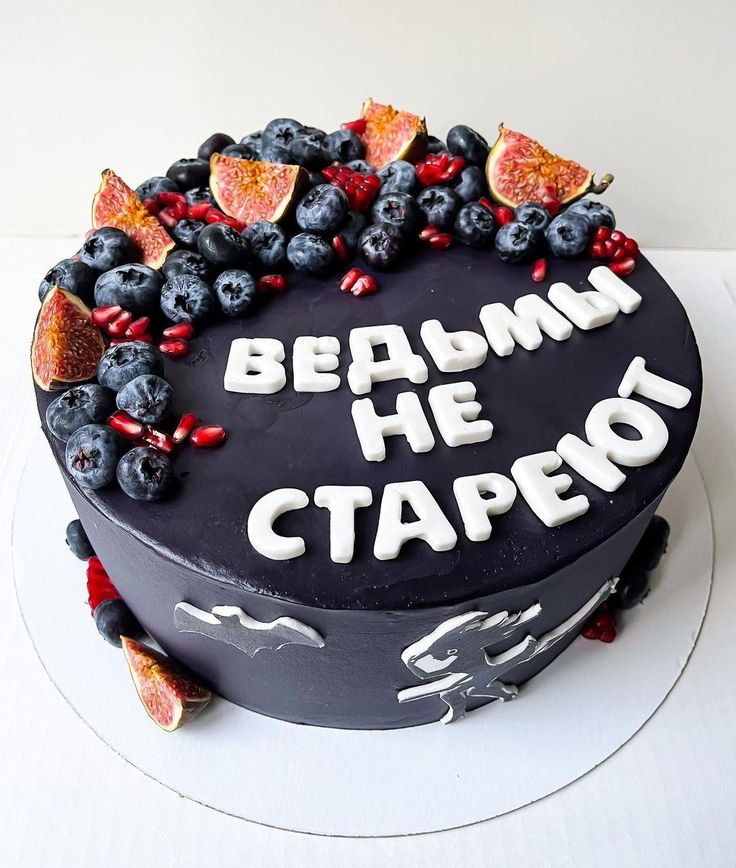 a black cake with fruit and writing on it