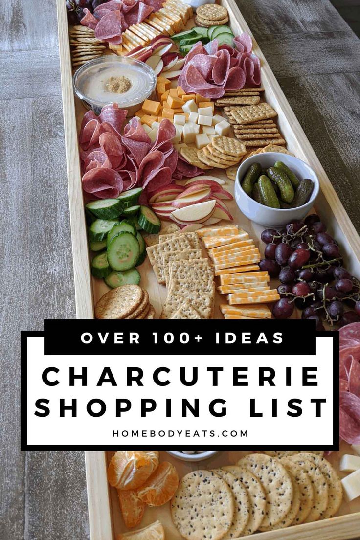 a wooden tray filled with cheese, crackers and meats on top of a table