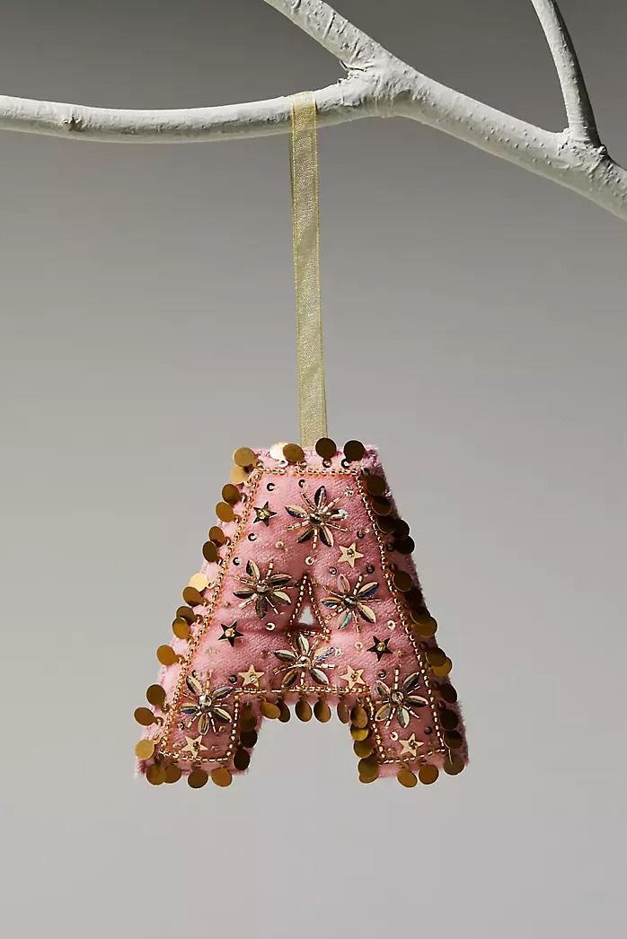 a pink ornament hanging from a tree branch