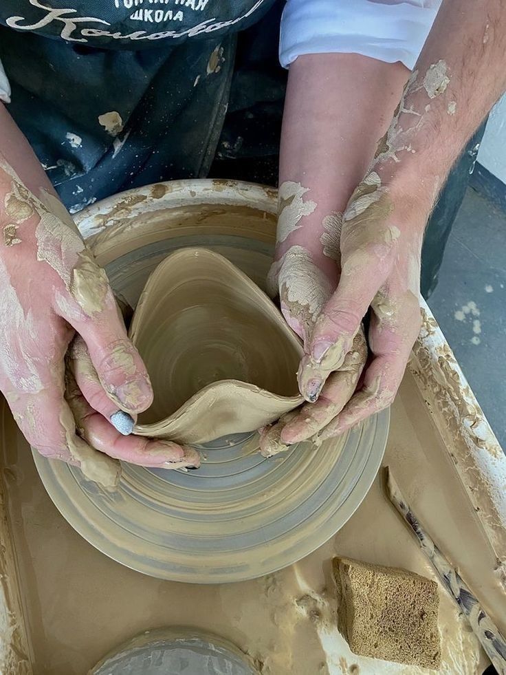 a person is making a pot on a potter's wheel