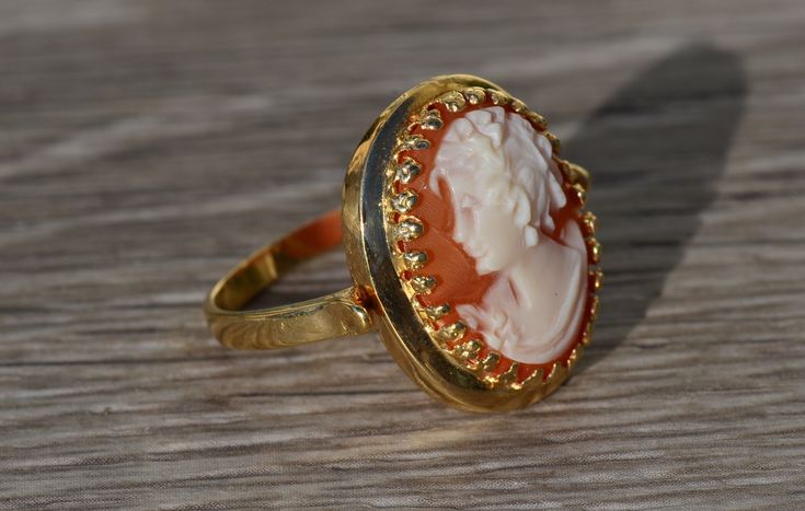 The Veena Ladies Antique Cameo Ring in 14K Yellow Gold. Crafted in 14 karat yellow gold, this ring is in excellent condition. Currently a finger size 8, this ring can be adjusted in size upon request. Each piece has been hand selected and meticulously identified and graded by a Graduate Gemologist who has been awarded a degree by the Gemological Institute of America (GIA). Please visit our Shop's About Page or our website for more information about our jewelry. Sizing for all rings is an additio 14k Gold Cameo Ring Fine Jewelry, Cameo 14k Gold Rings For Anniversary, 14k Gold Cameo Rings For Anniversary, Cameo Fine Jewelry Rings, Yellow Gold Cameo Signet Ring, Fine Jewelry Cameo Rings For Weddings, Gold Round Cameo Signet Ring, Fine Jewelry Cameo Wedding Ring, Gold Cameo Rings For Anniversary