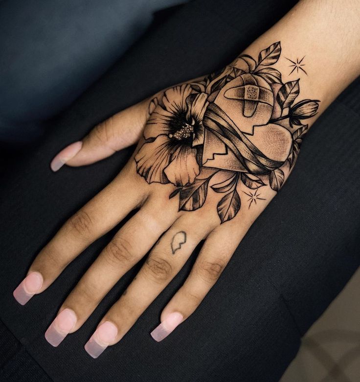 a woman's hand with a flower and cross tattoo on the middle of it