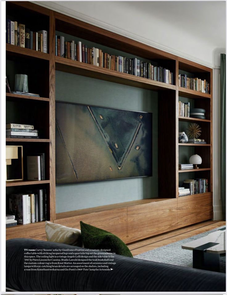 a living room filled with furniture and bookshelves covered in lots of bookcases