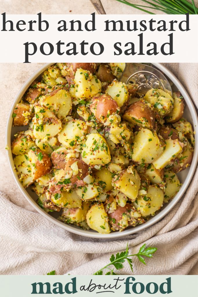 a bowl filled with potatoes and herbs on top of a table