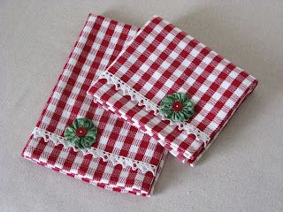 two red and white gingham cloths with green buttons on them, sitting on a table