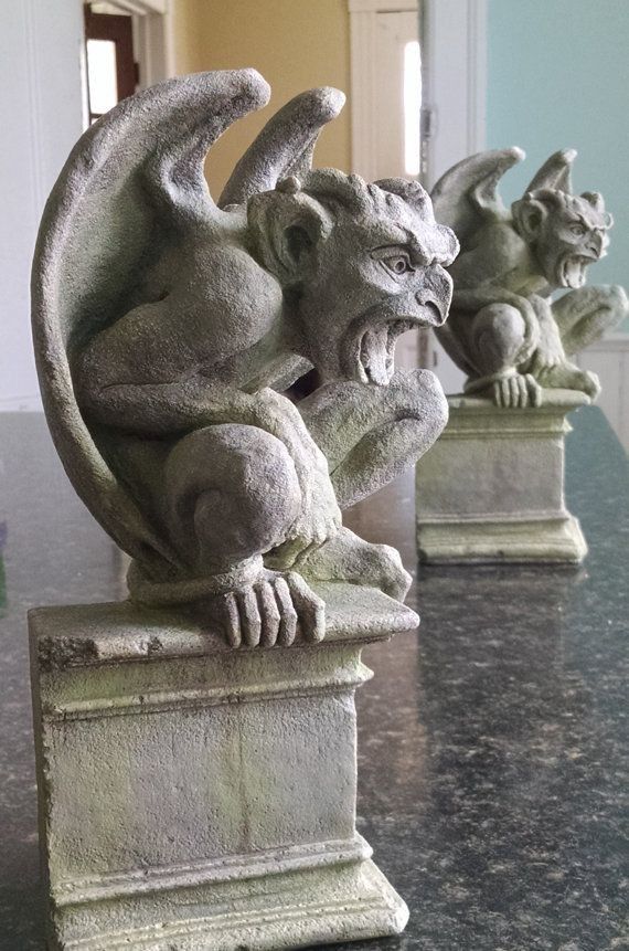 three gargoyle statues sitting on top of a marble table next to each other