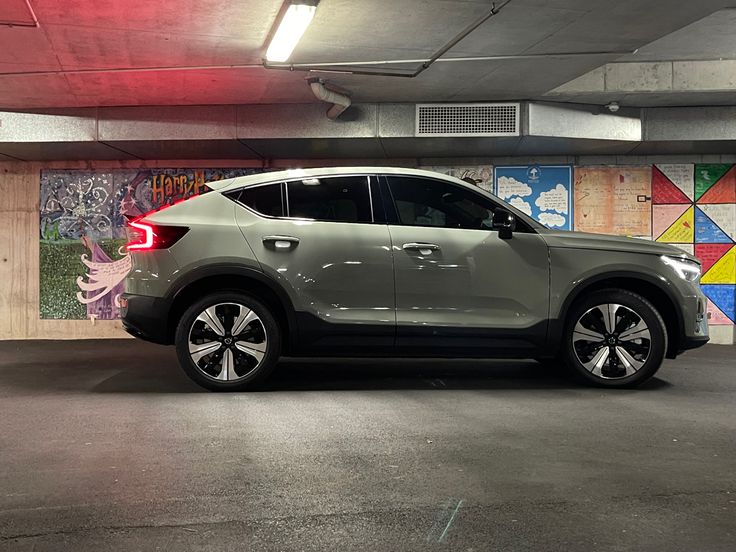 a car parked in a parking garage with graffiti on the walls