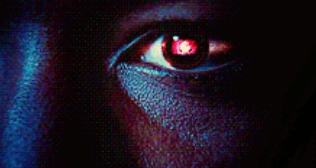 a close up of a person's eye with red light coming from the iris