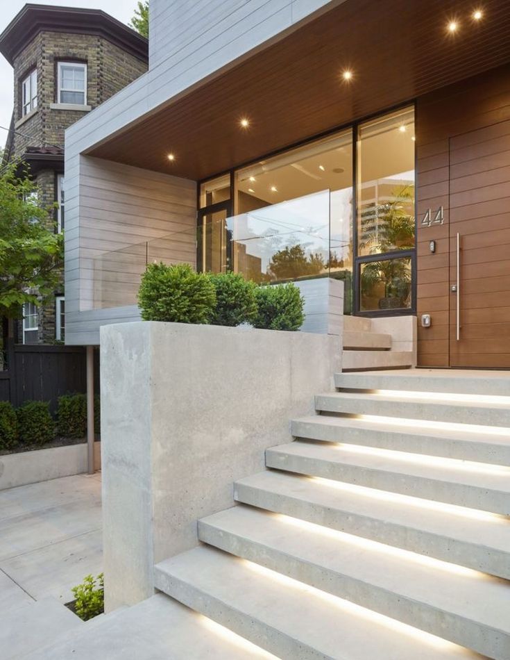 some steps leading up to a house with lights on them and plants in the front