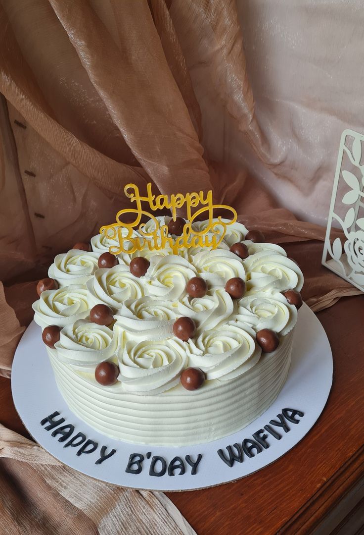 a birthday cake with white frosting and chocolate decorations