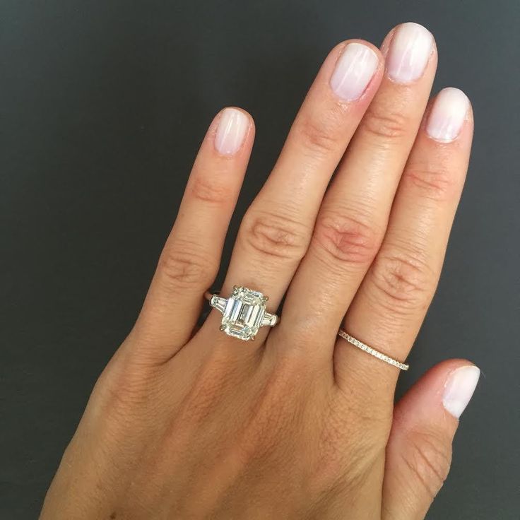 a woman's hand holding an engagement ring with a diamond in the middle and a band around it