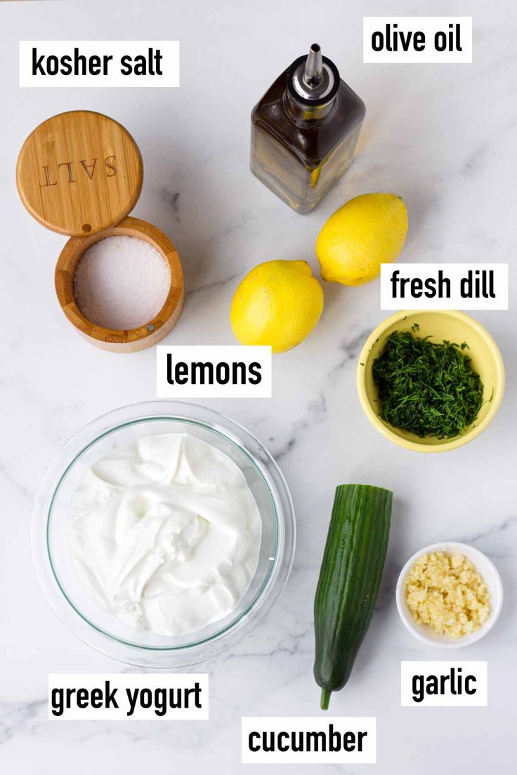 ingredients to make lemon cucumber salad laid out on a white marble counter top