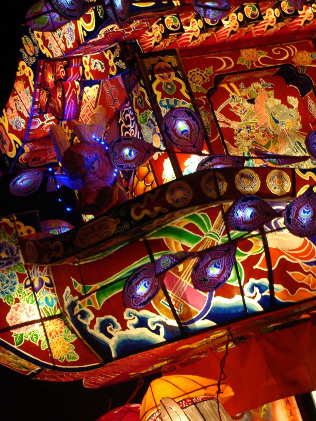 the lights are brightly lit up on the building's roof and ceiling, which is decorated with colorful designs