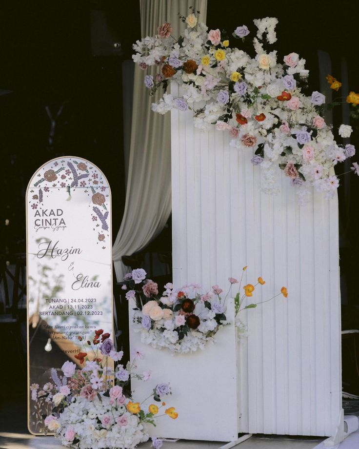 a white grave with flowers on it next to a sign