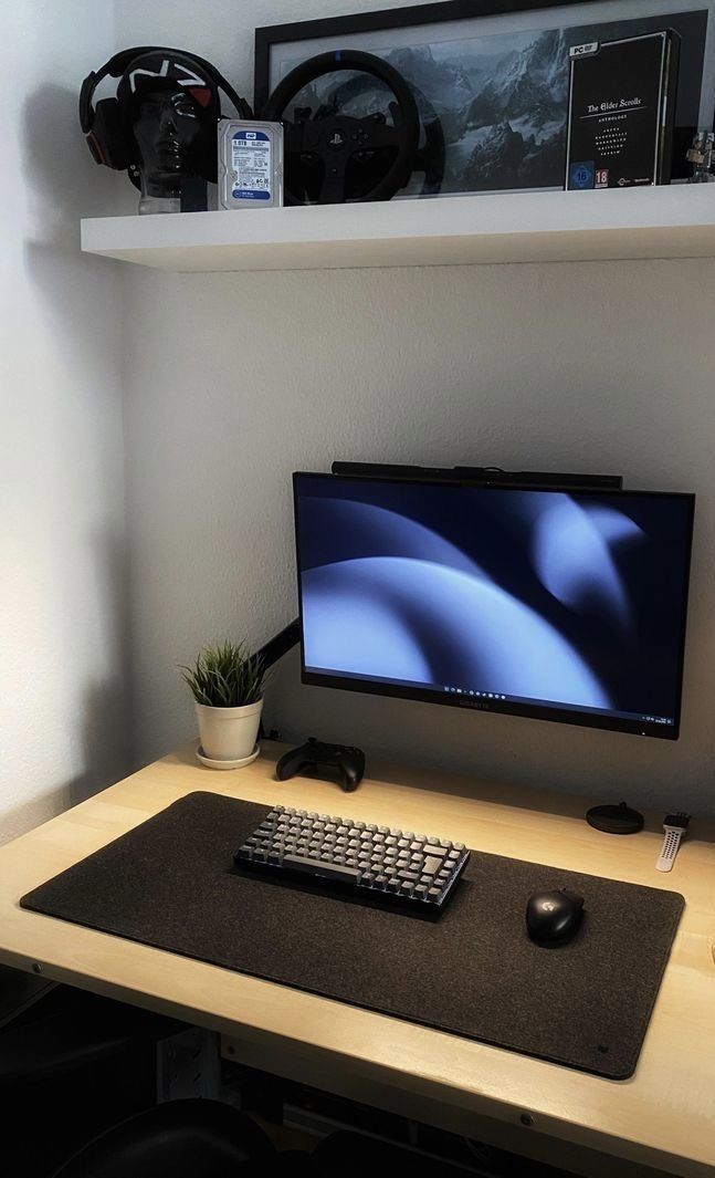 a computer monitor sitting on top of a wooden desk next to a keyboard and mouse