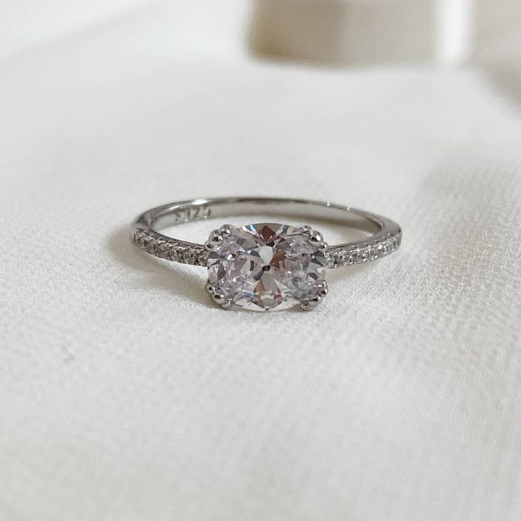 a diamond ring sitting on top of a white cloth