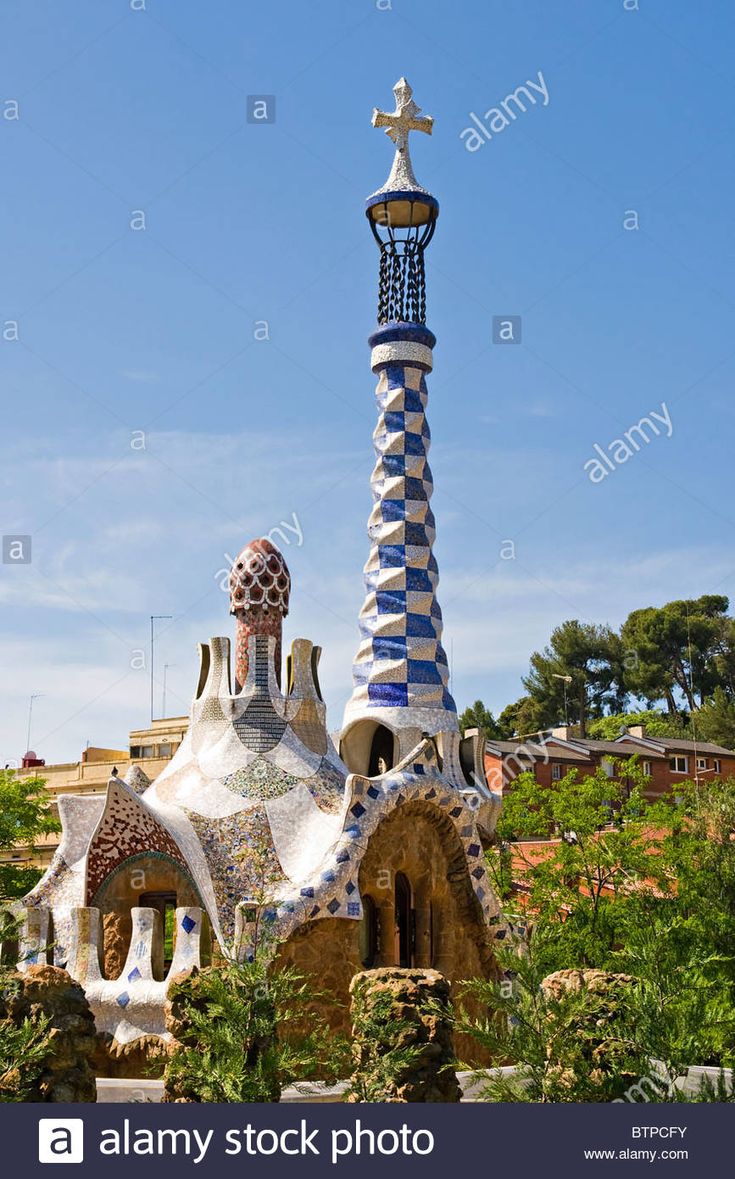 an unusual building in barcelona, spain with a cross on top and a clock tower behind it - stock image