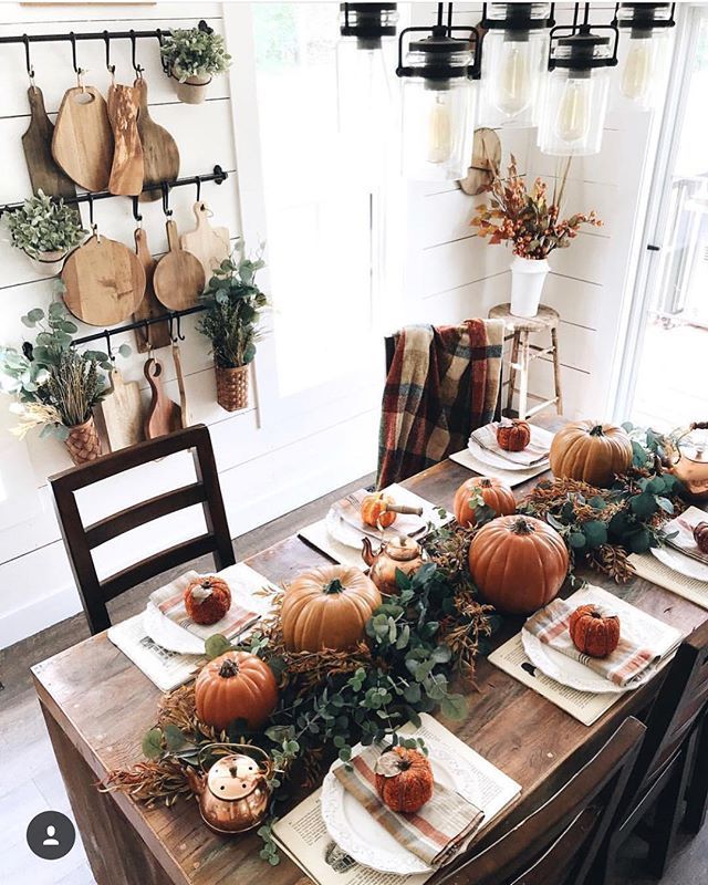 a wooden table topped with lots of pumpkins