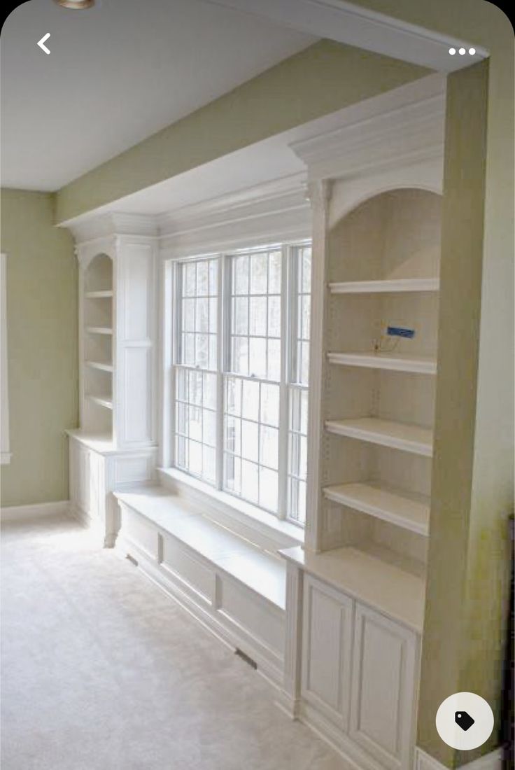 an empty living room with built in bookshelves