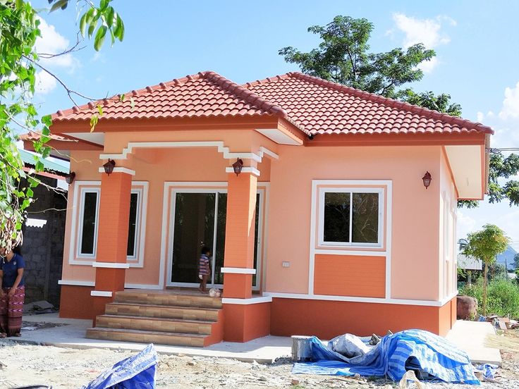 a small pink house sitting on top of a dirt field