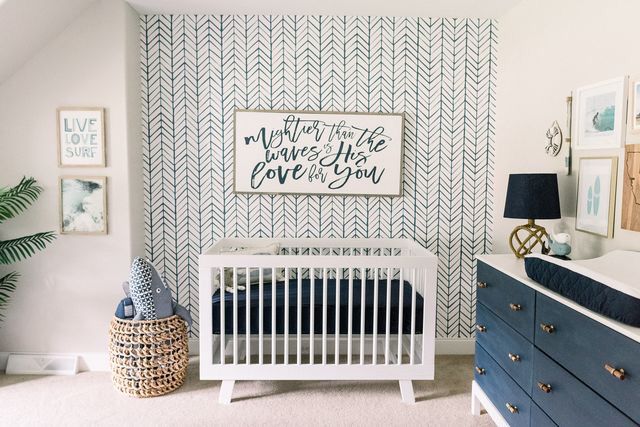 a baby's room with a crib, dresser and pictures on the wall