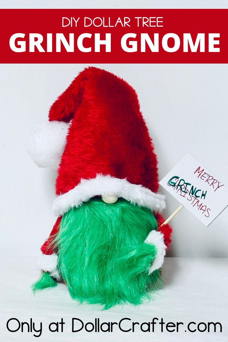 a green stuffed animal wearing a santa hat and holding a sign that says grinch gnome only at dollarcrafter com