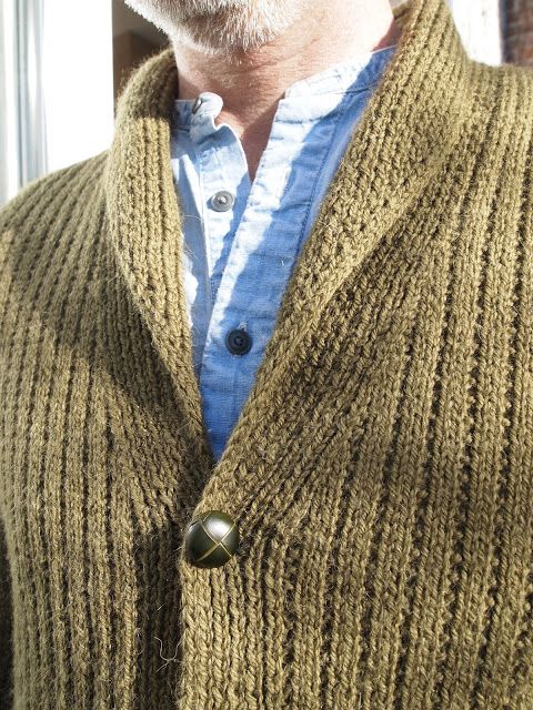 an older man wearing a knitted sweater and cardigan with buttons on the lapel