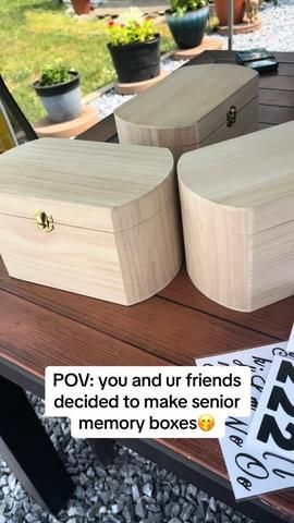 two wooden boxes sitting on top of a table next to a sign that says pov you and ur friends decided to make senior memory boxes