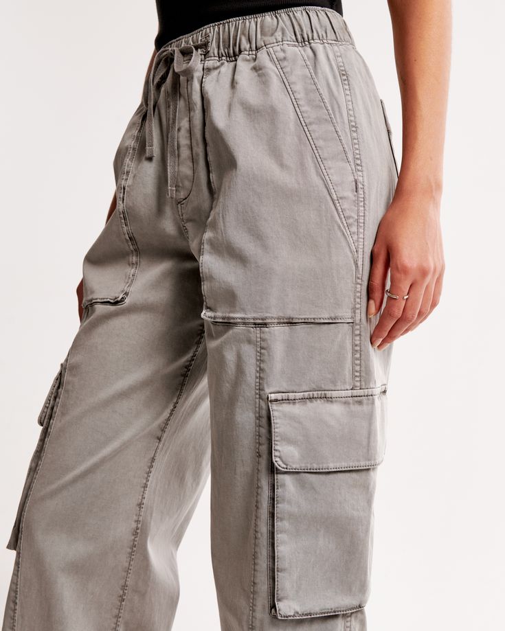 Baggy cargo pants, that are high rise but can be worn at mid or low comfortably, in a drapey twill fabric with an all-over garment dye wash effect and baggy silhouette. Features cargo-inspired details, pockets, zip-hem adjustability and a fully elasticated waistband with functional drawcords. Utility Cotton Cargo Jeans With Elastic Waistband, Utility Style Cotton Cargo Jeans With Elastic Waistband, Relaxed Fit Cargo Jeans For Spring, Everyday Parachute Pants With Side Pockets For Spring, Utility Cargo Pants For Everyday Spring Wear, Utility Style Everyday Cargo Pants For Spring, Mid-rise Cotton Cargo Parachute Pants, Relaxed Fit Cargo Pants With Cargo Pockets For Spring, Utility Cargo Bottoms With Relaxed Fit