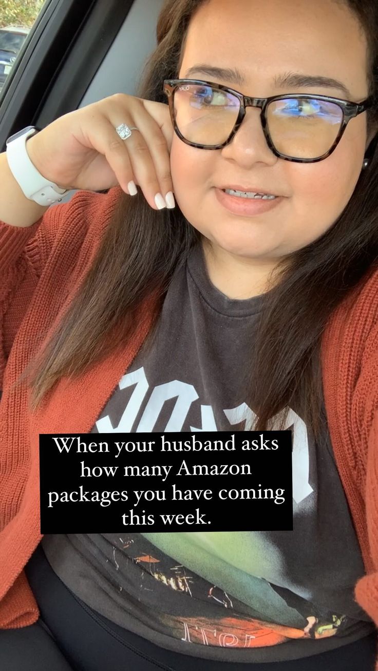 a woman wearing glasses sitting in the back seat of a car