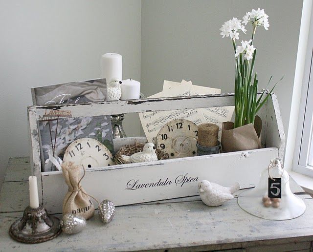 an old wooden box filled with assorted items sitting on top of a table next to a window