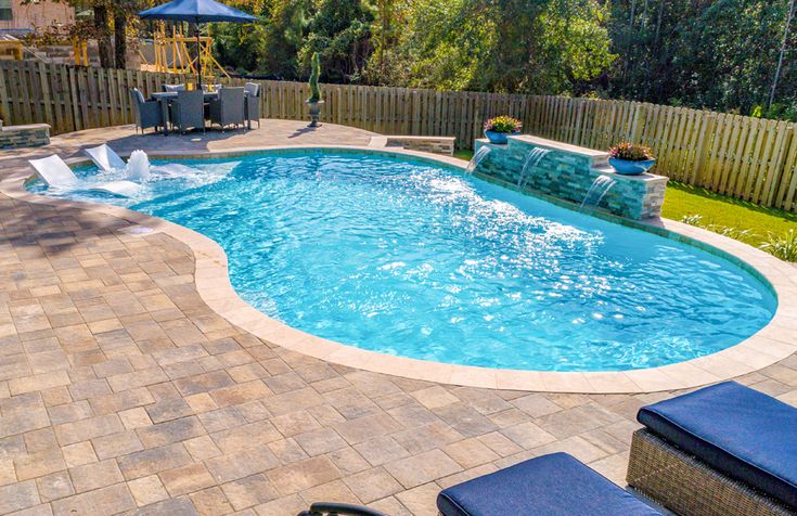 a backyard with a swimming pool and patio furniture