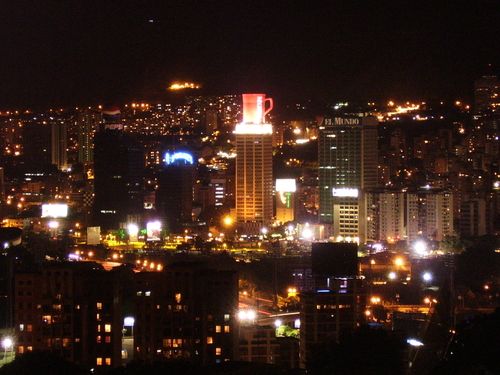 the city is lit up at night with bright lights on it's skyscrapers